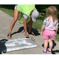 Storm drain stencilling to spread message that what goes down storm drains goes to our lakes and rivers