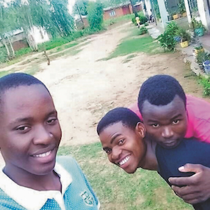 3 boys in village in Malawi